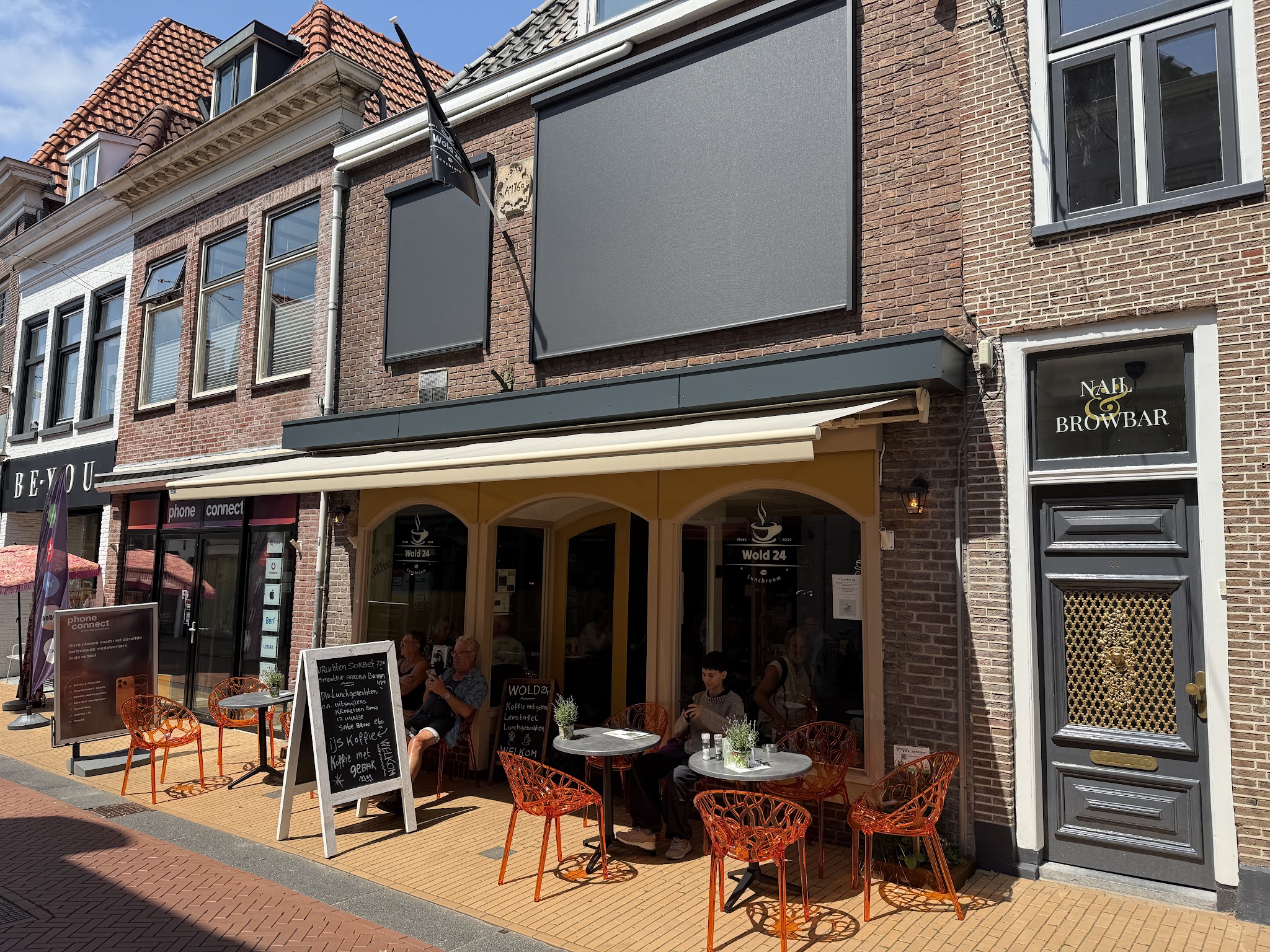 Gevel van Wold24 met de vlag en het jaartal op de gevelsteen